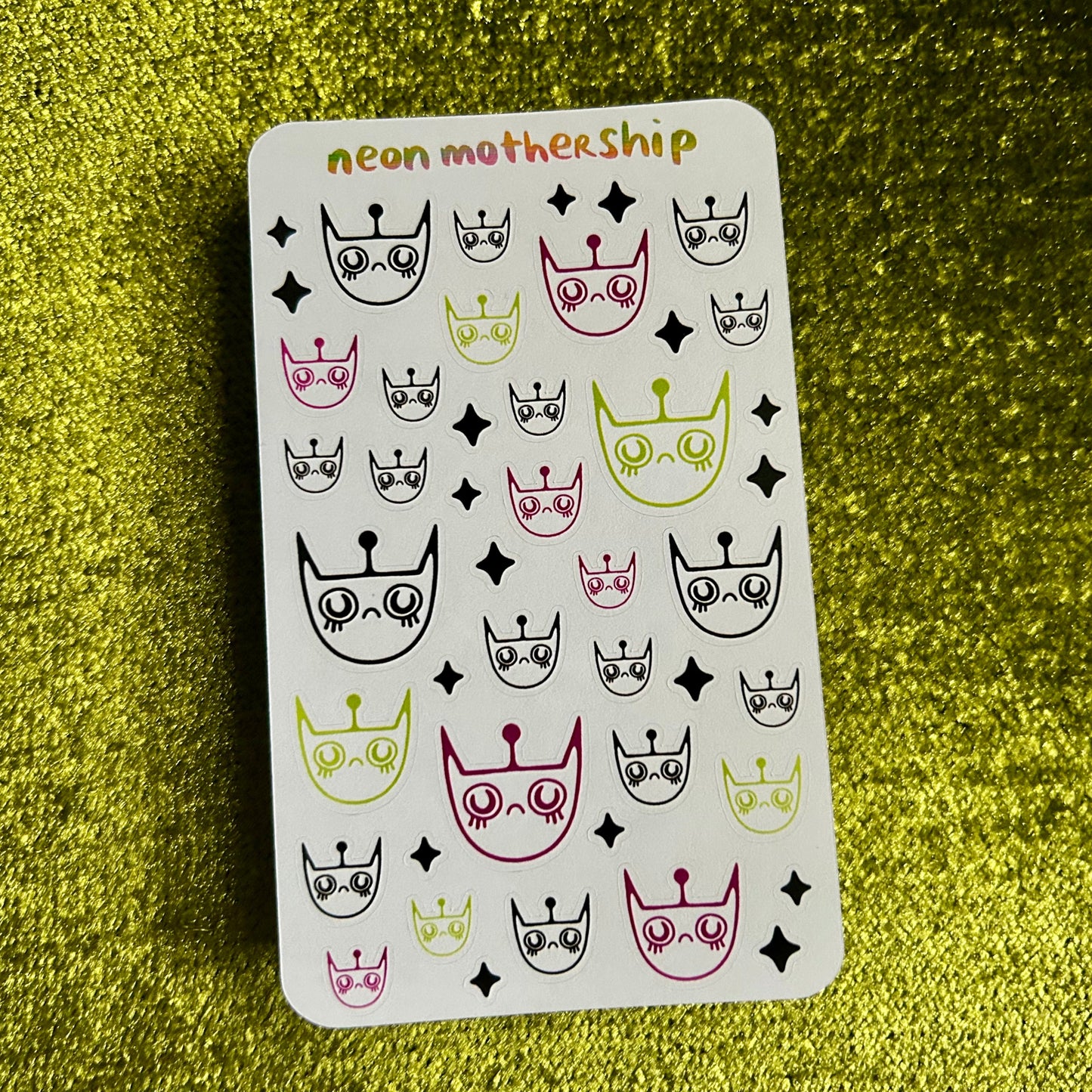 Sticker sheet with various designs on a green glittery background