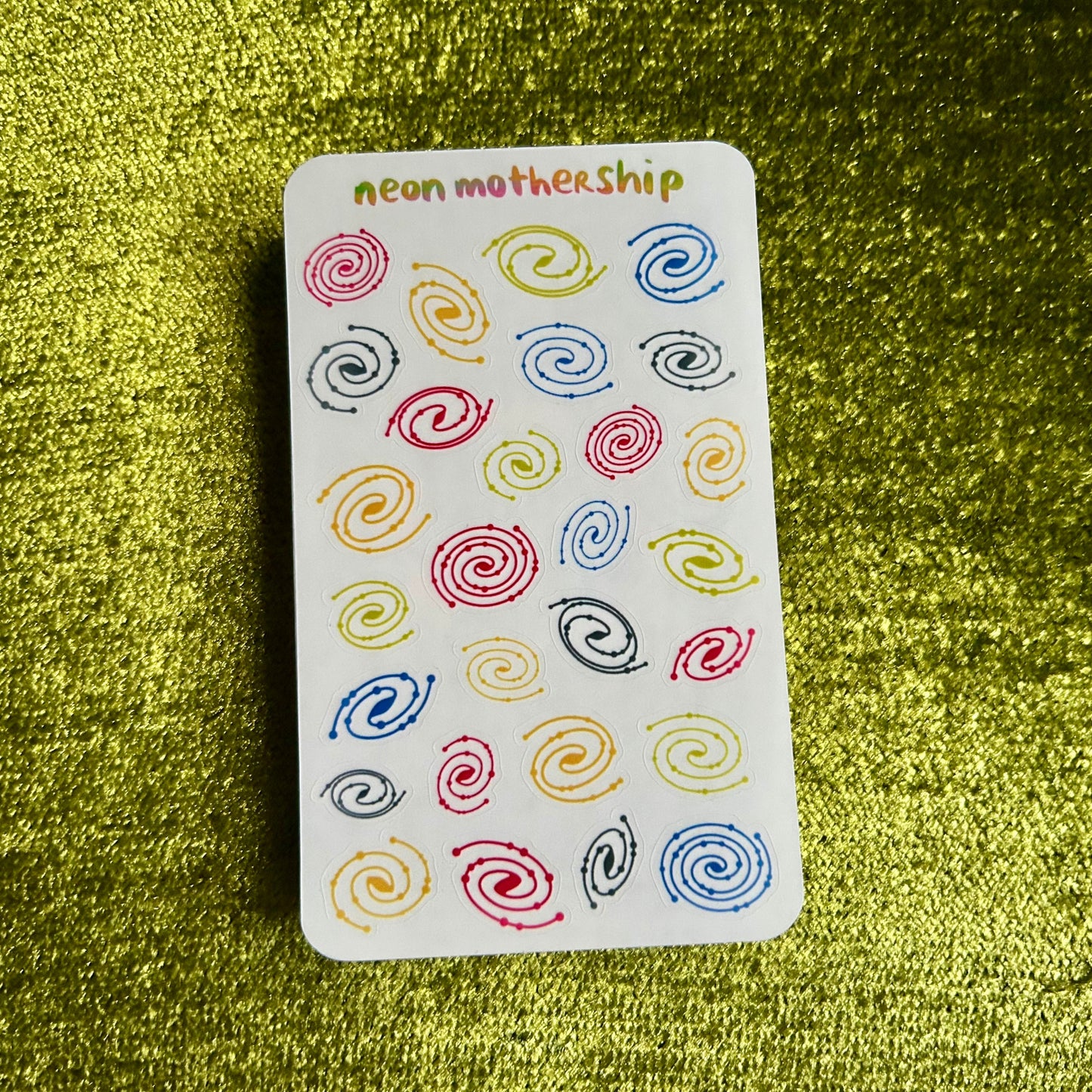 sticker sheet with colorful spiral designs on a green textured background