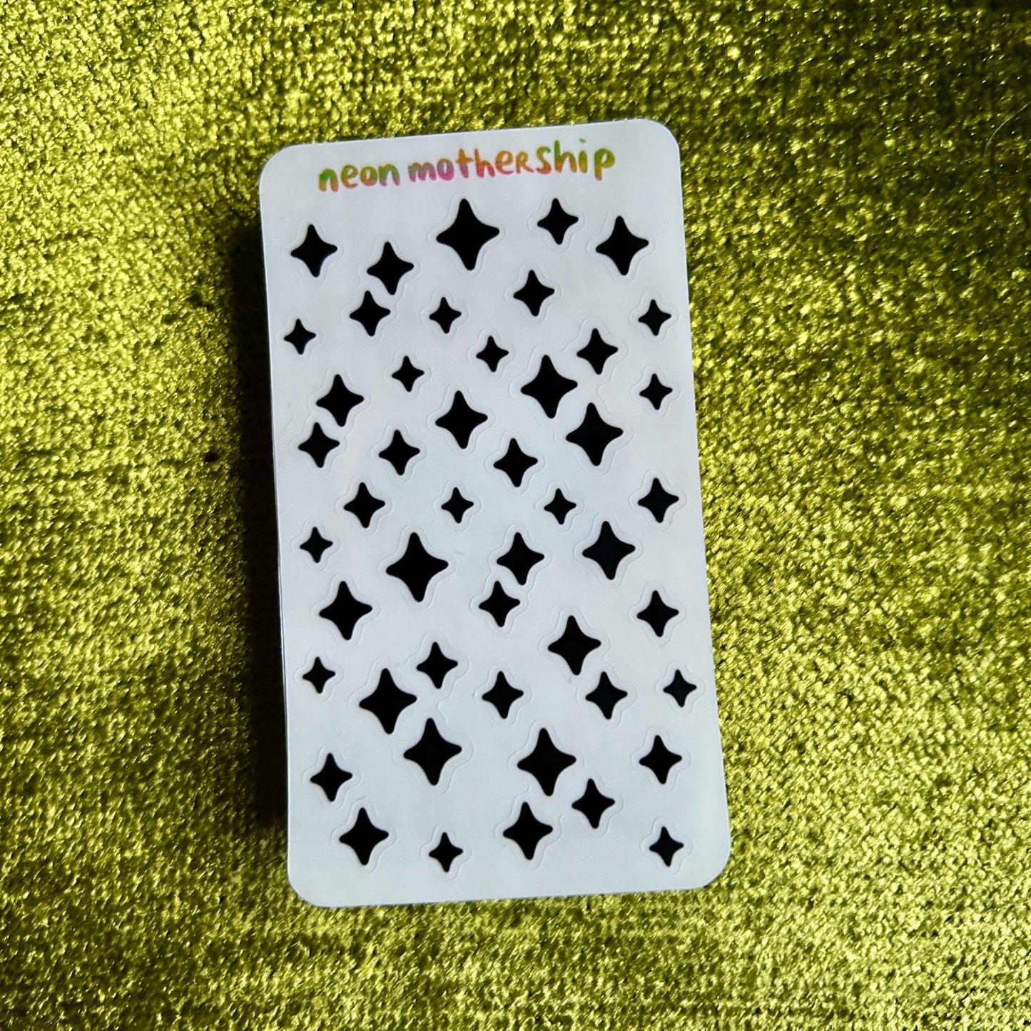 White card with black star patterns on a green textured background
