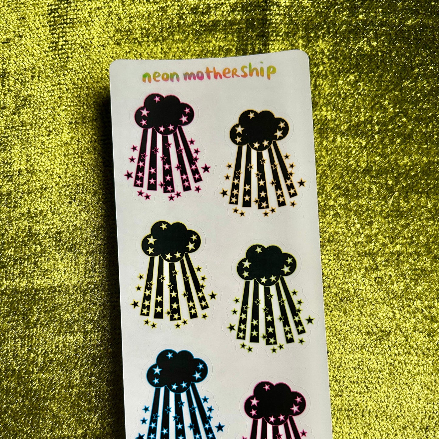 Sheet of cloud-shaped stickers with star details on a green textured background