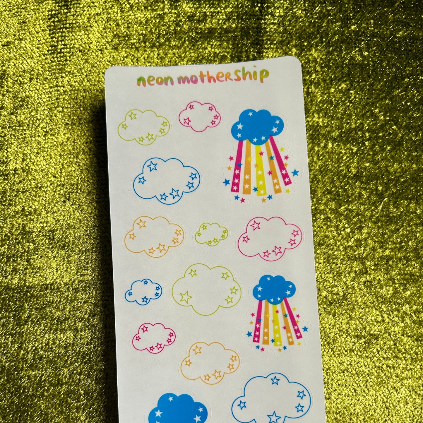 Sticker sheet with colorful cloud designs on a green textured background