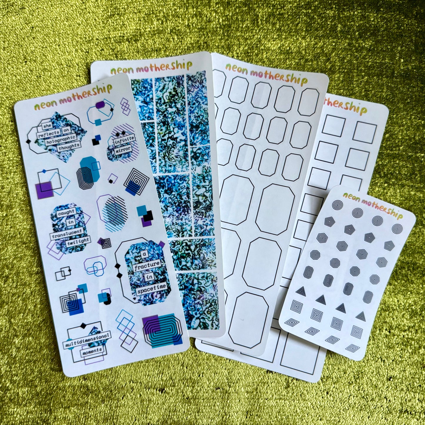 Collection of sticker sheets on a textured green surface