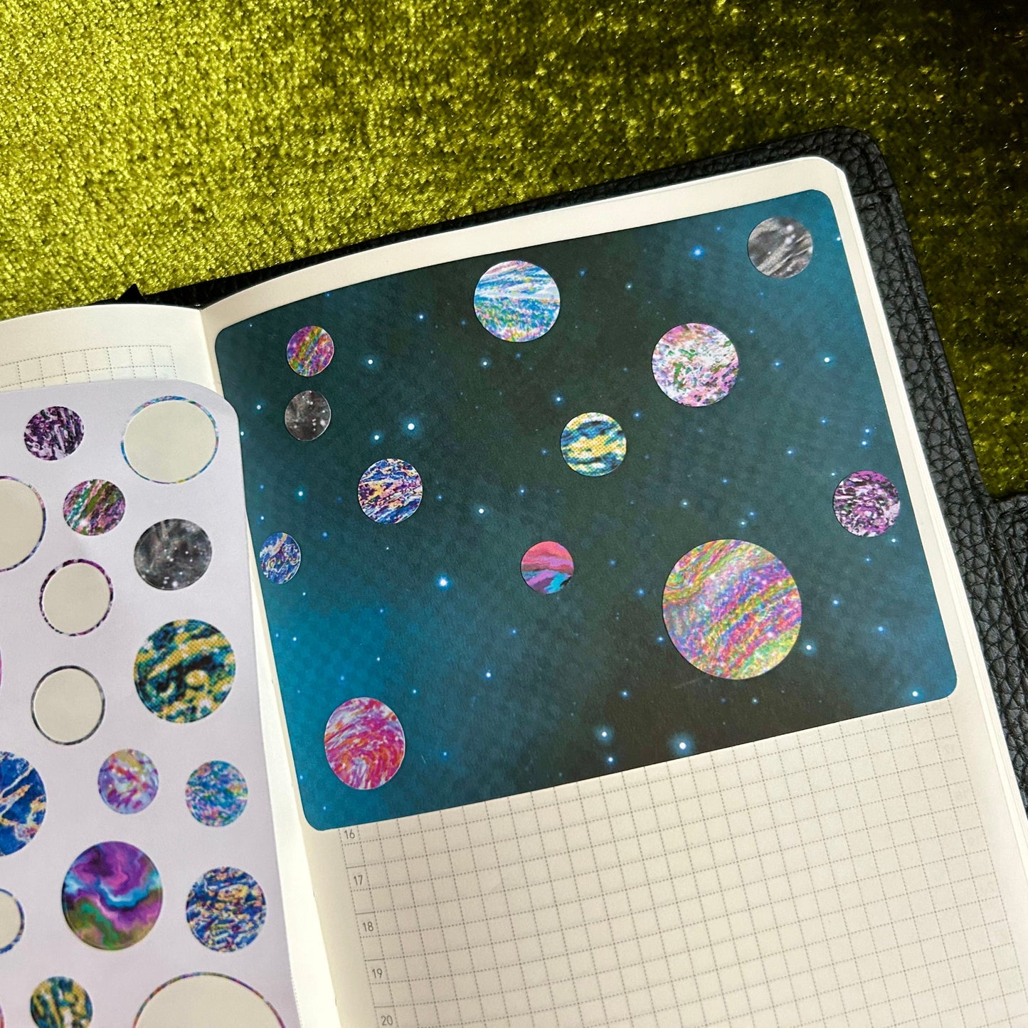 Sticker album with space-themed stickers on a green glittery background