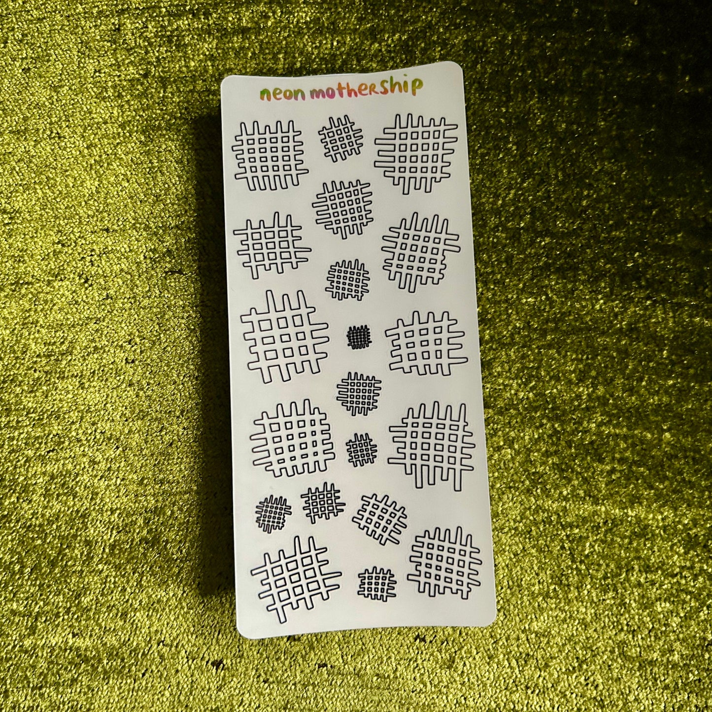 Sticker sheet with geometric patterns on a textured green surface
