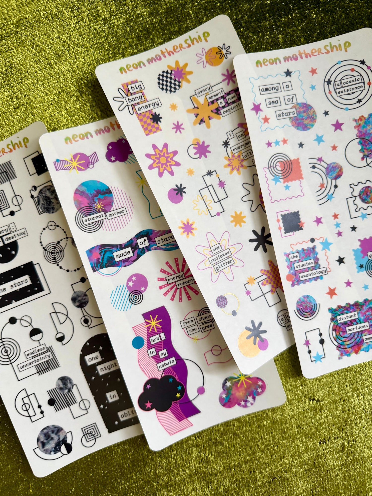 four sticker sheets featuring cosmic motifs on a green background