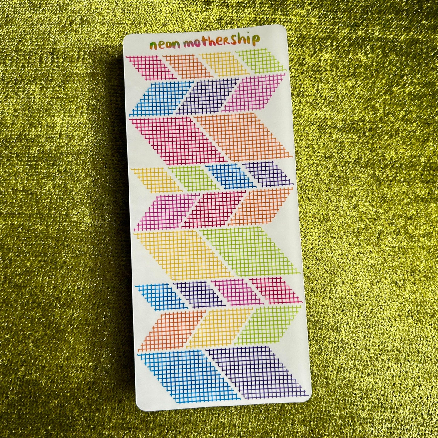 Colorful geometric patterned stickers on a green textured surface
