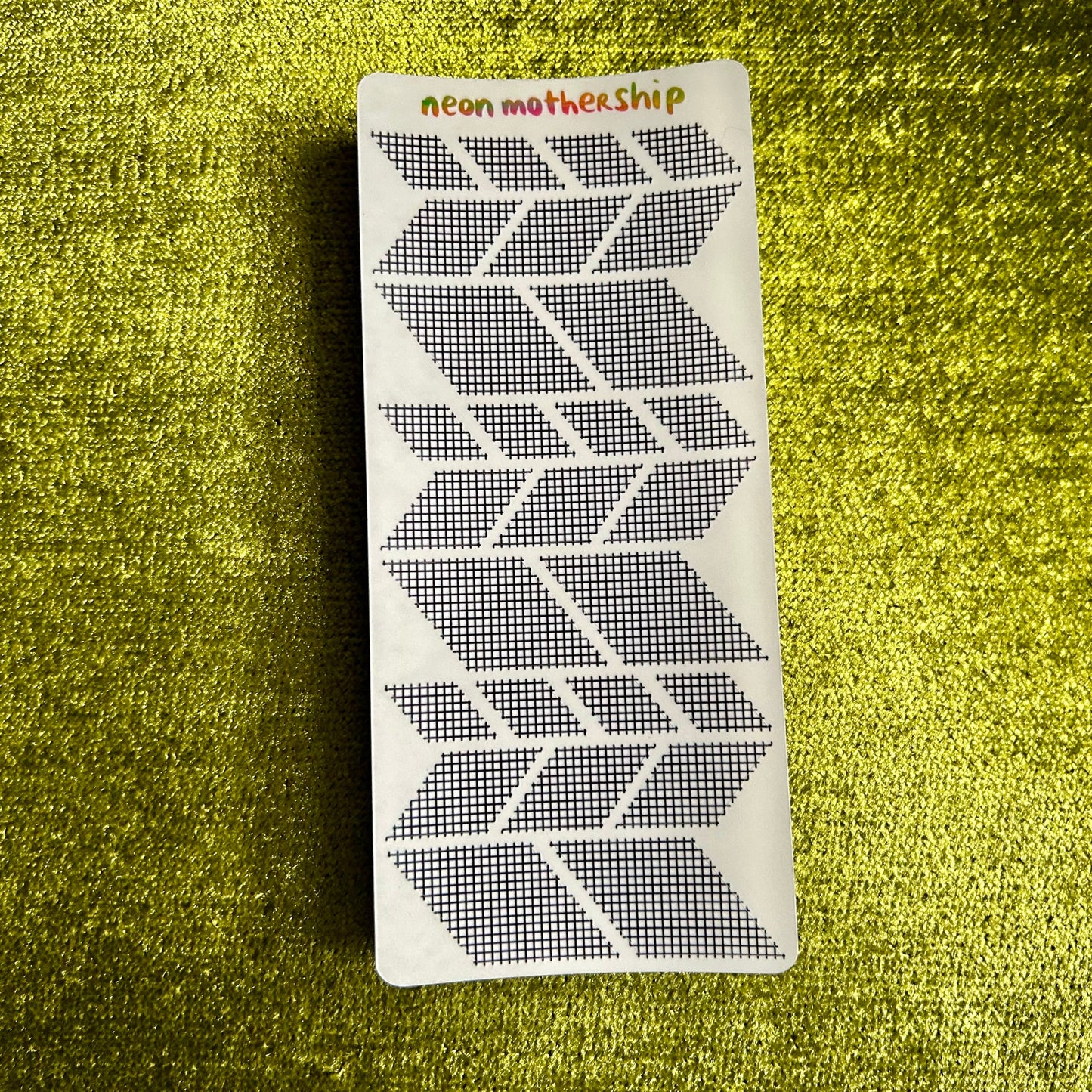 sticker sheet with geometric pattern on a green textured surface