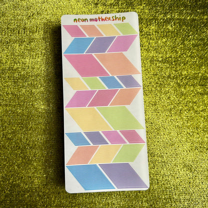 Colorful geometric patterned stickers on a green textured surface