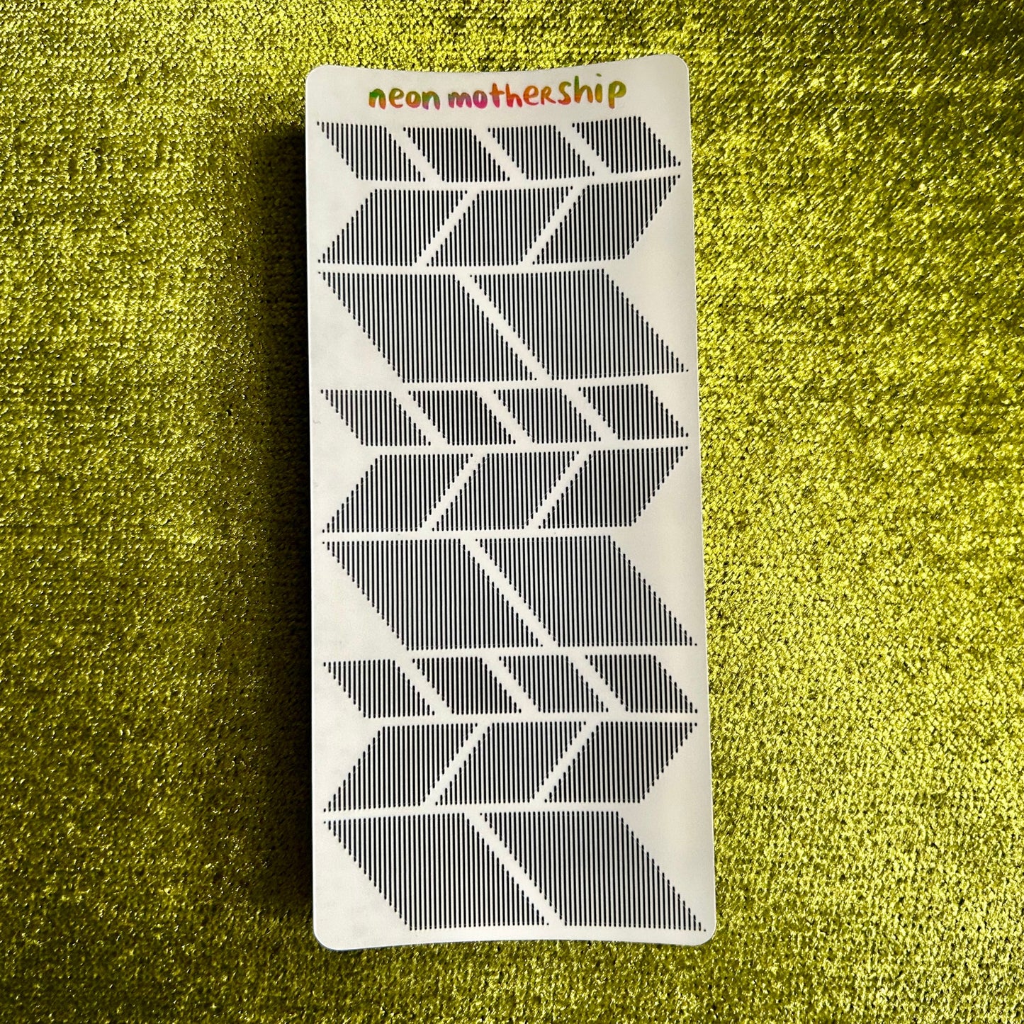 sticker sheet with geometric pattern on a textured green surface