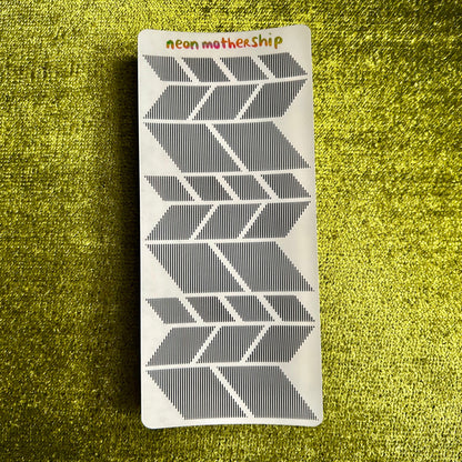 sticker sheet with geometric pattern on a textured green surface
