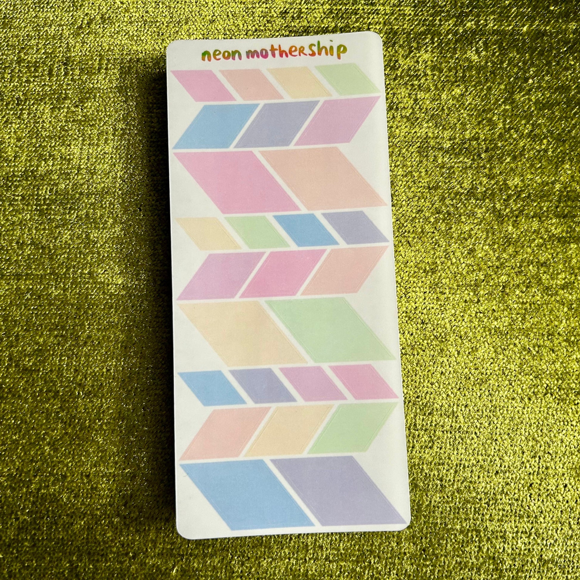 Geometric patterned sticker sheet on a textured green surface