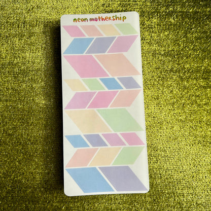 Geometric patterned sticker sheet on a textured green surface