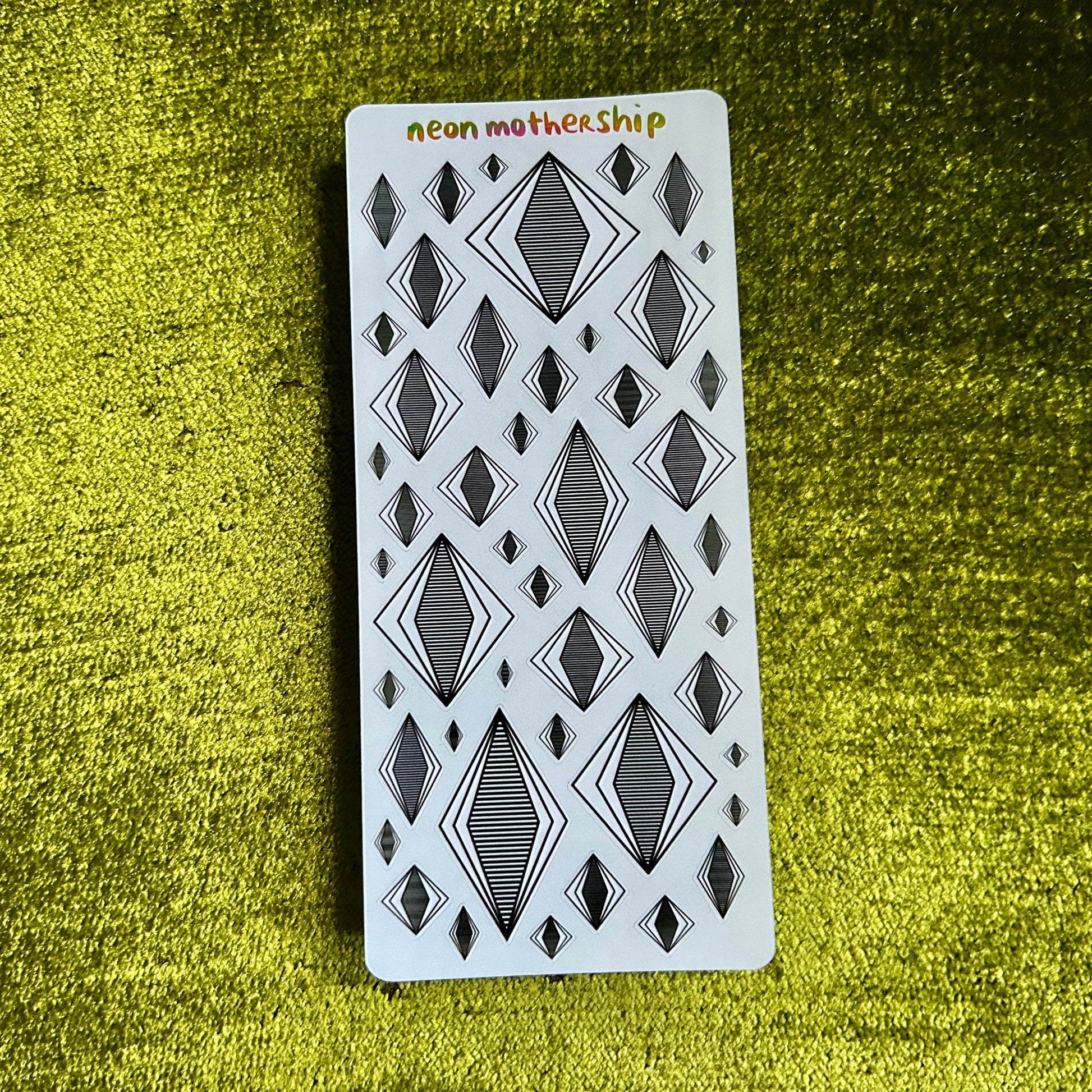 Sticker sheet with geometric pattern on a green textured surface