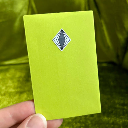 Green square card with a logo held by a hand against a green background