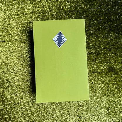 Green envelope with a blue diamond-shaped logo on a green textured surface