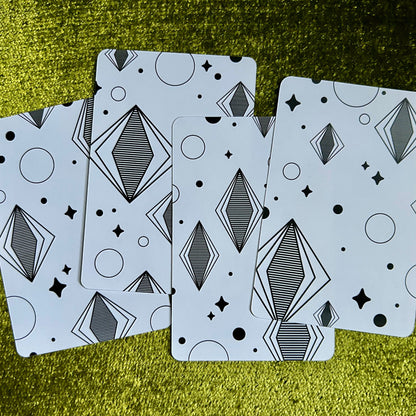 Four art prints with geometric patterns on a green textured surface