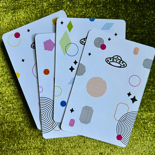 four sticker sheets with geometric patterns on a green textured surface