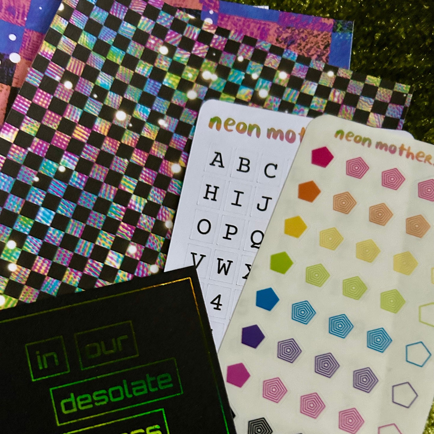 Collection of colorful stickers and a black book on a textured surface