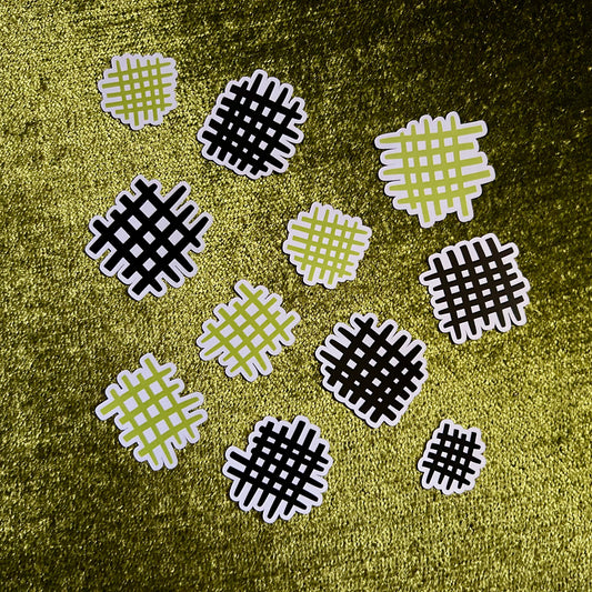 Patterned die cut stickers on a textured green surface