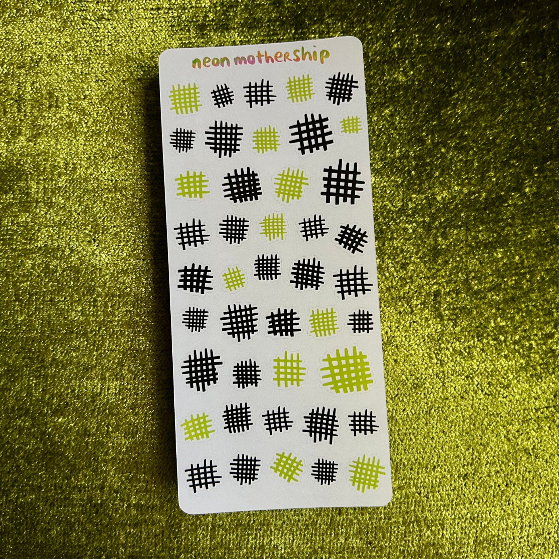 sticker sheet with black and green pattern on a green textured background