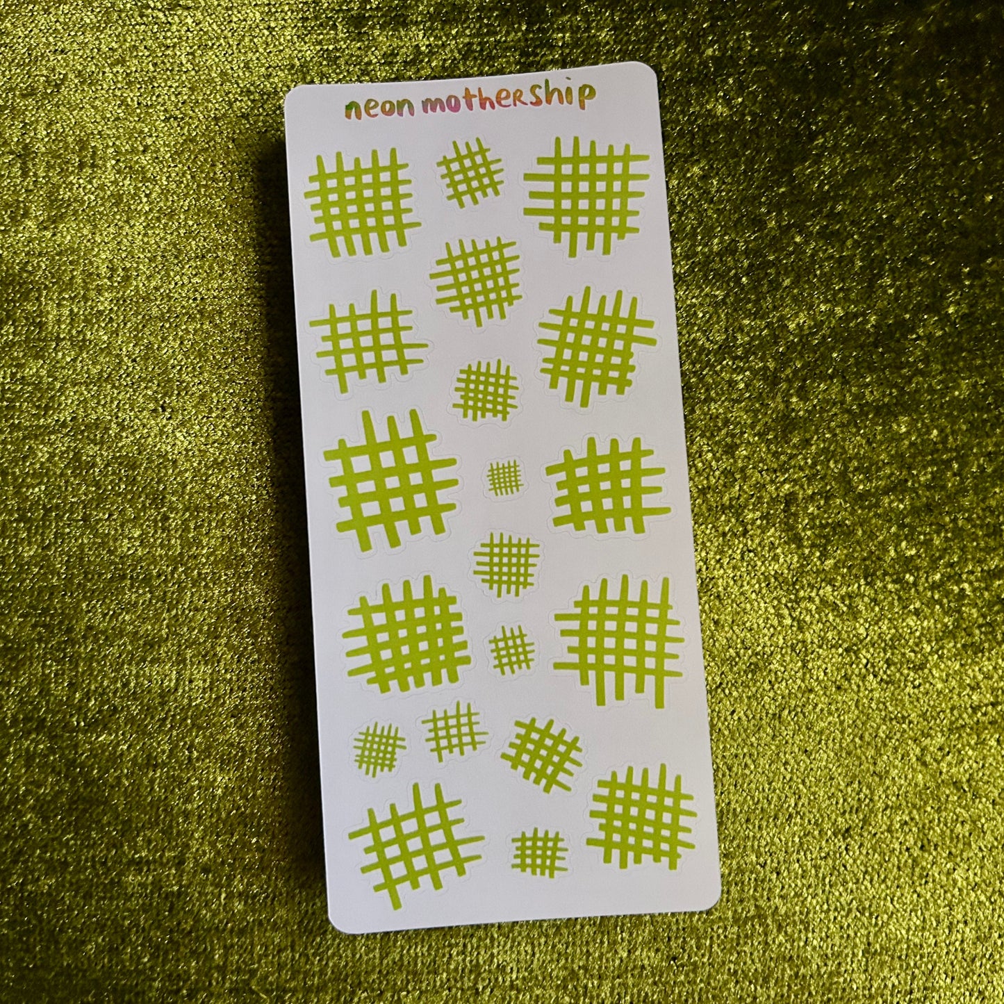 sticker sheet with green grid patterns on a green textured background