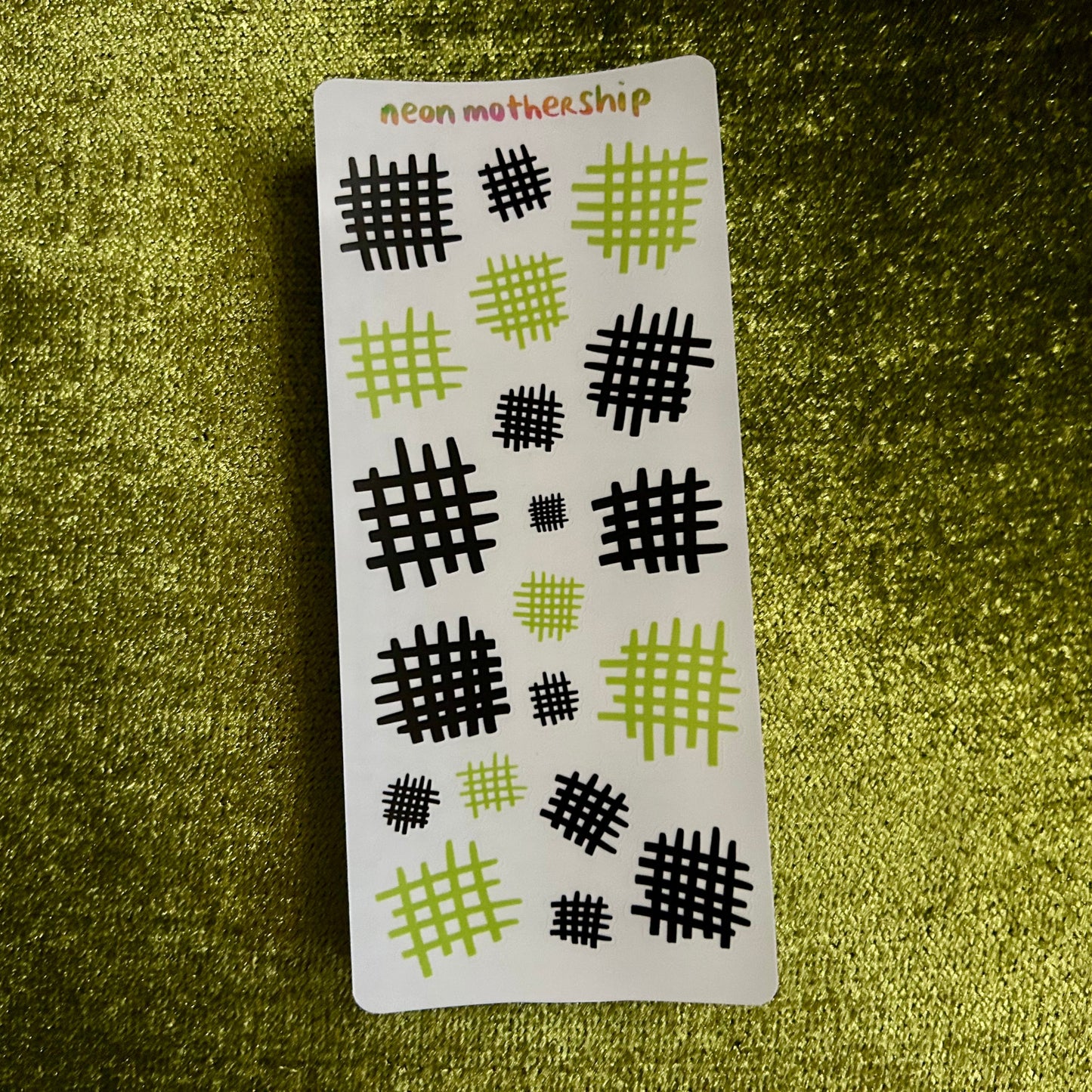Sticker with geometric patterns on a green textured background