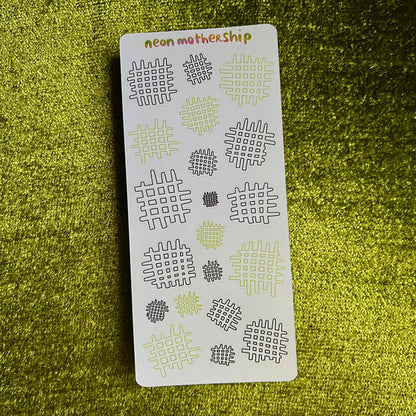 Sheet of patterned stickers with 'neon mother ship' branding on a green textured background