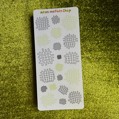 Sheet of patterned stickers with 'neon mother ship' branding on a green textured background