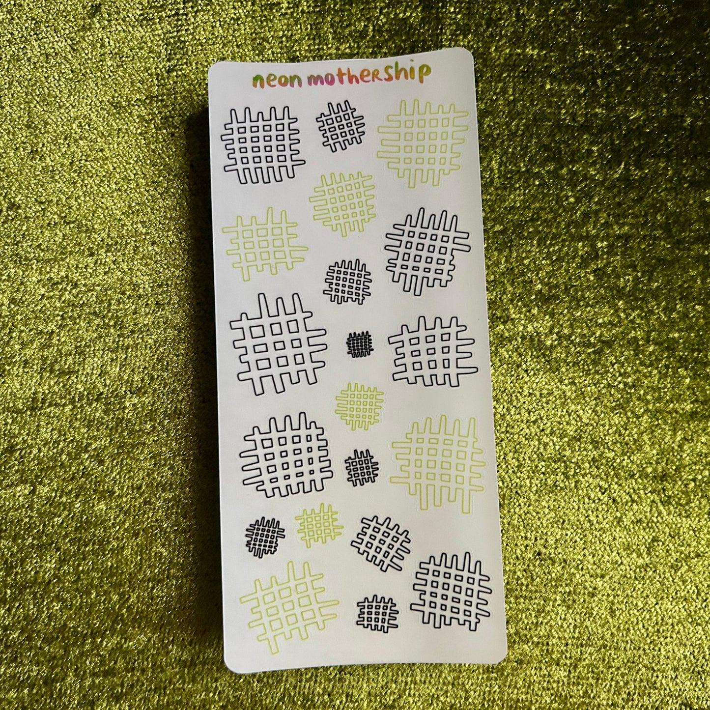 sticker sheet with geometric patterns on a green textured surface