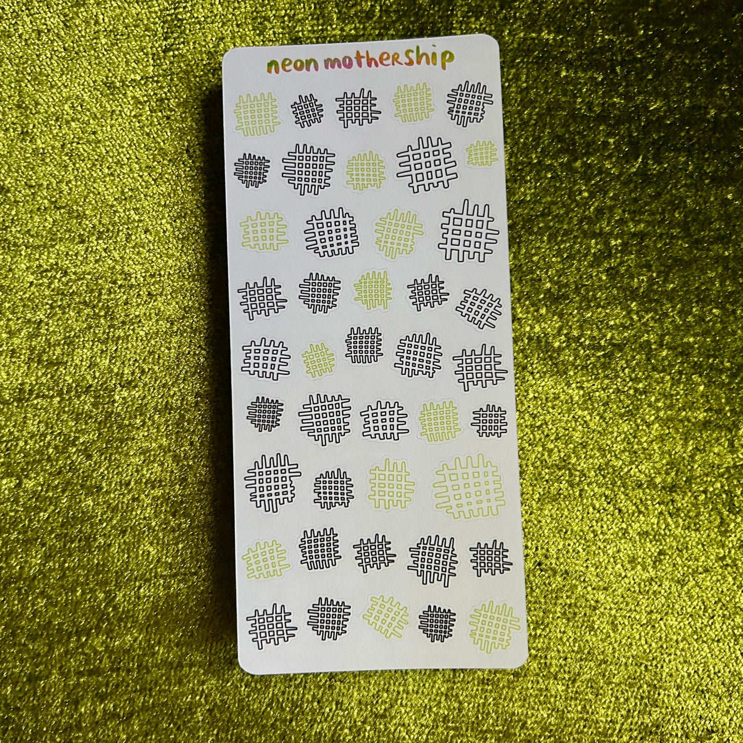 sticker sheet with geometric patterns on a green textured surface