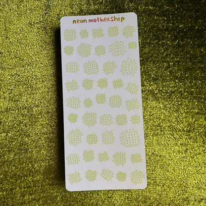 Sheet of green waffle-patterned stickers on a green textured surface