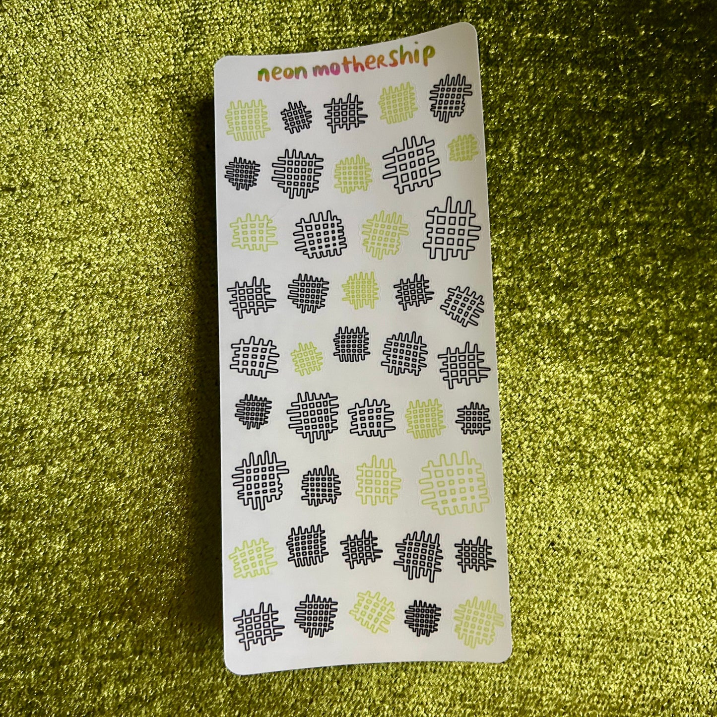 Sticker sheet with geometric waffle pattern on a green textured background