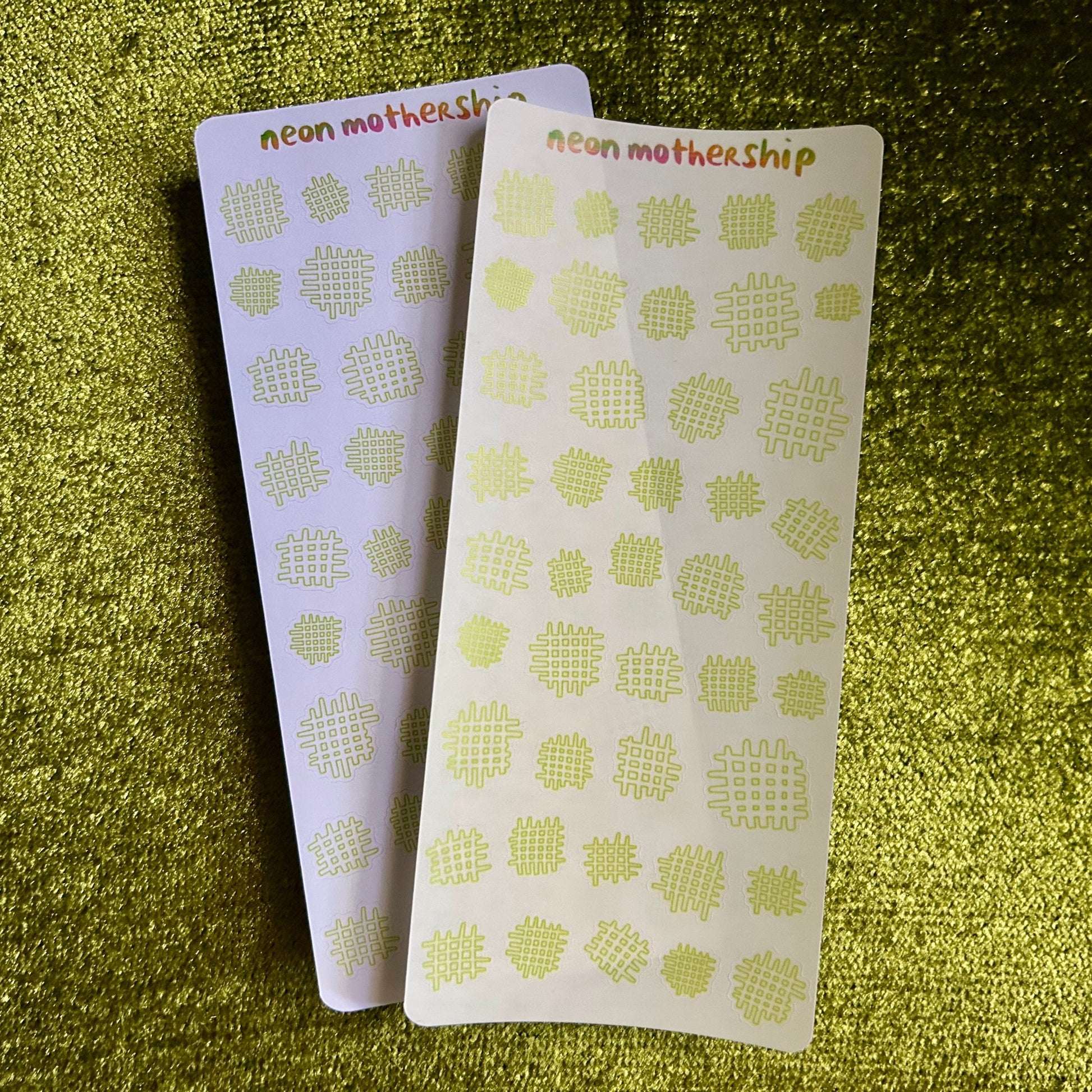 Two neon mothership products with a geometric pattern on a green textured background