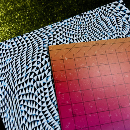 postcard with a black and white pattern on a cutting mat with grid lines.