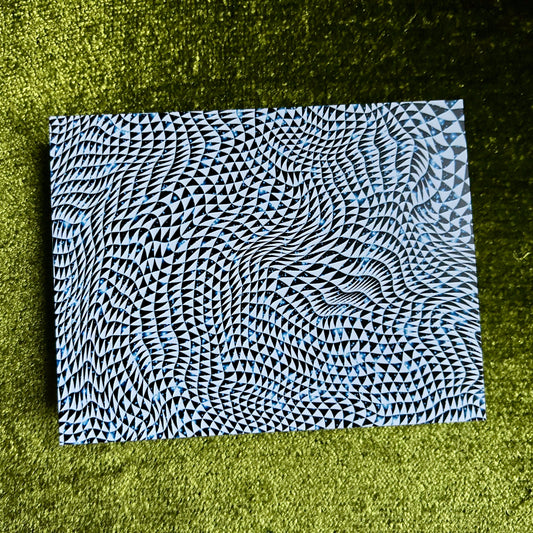 Black, blue and white cosmic patterned postcard on a green grass background
