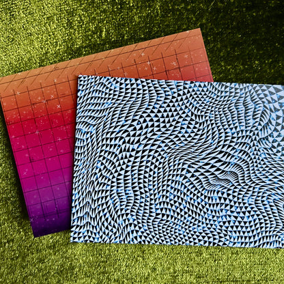 Two neon patterned postcards on a green grass background