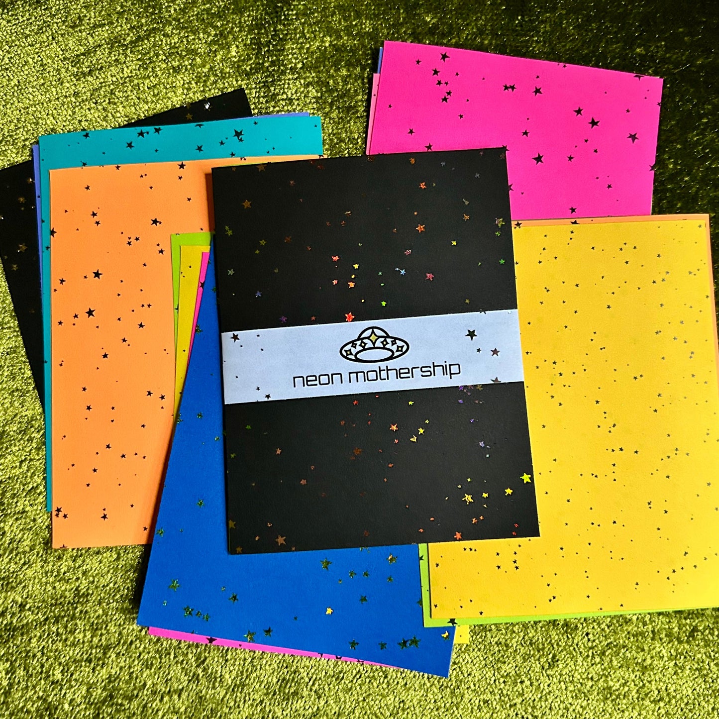Colorful papers with star patterns on a green textured surface