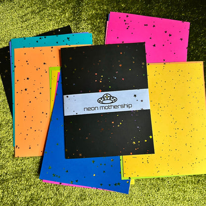Colorful papers with star patterns on a green textured surface