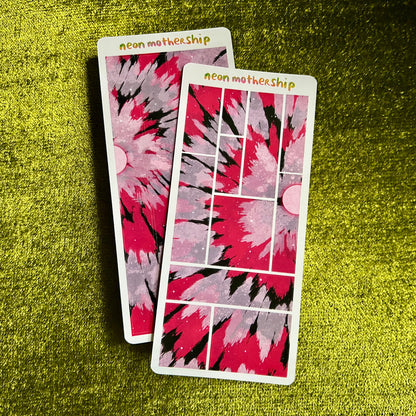 Two sticker sheets with a red and black abstract design on a green textured surface