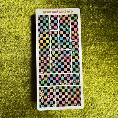 Checkered sticker sheet with 'neon mother ship' text on a green textured background