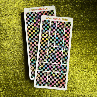 Two sheets of checkered stickers with 'neon mothership' branding on a green textured surface.