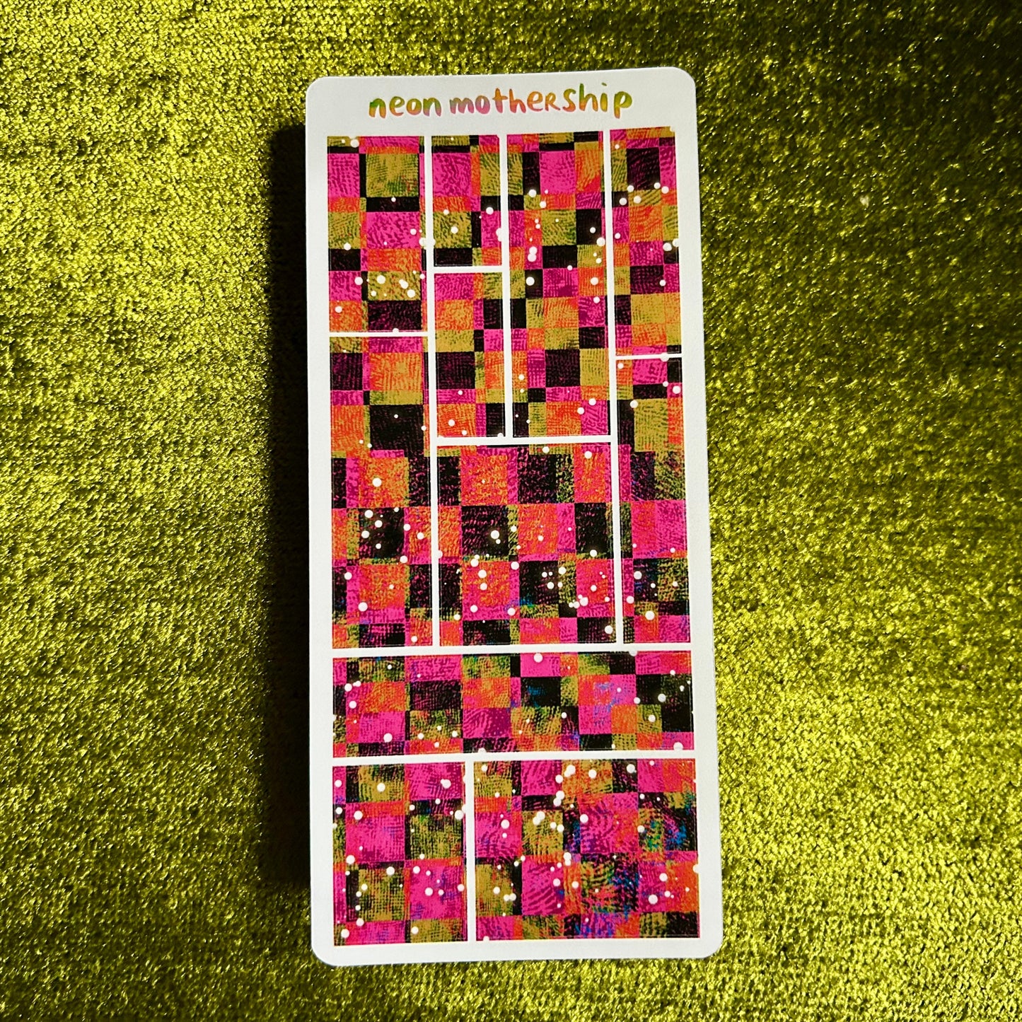 Sticker with a colorful pixelated design on a green textured background