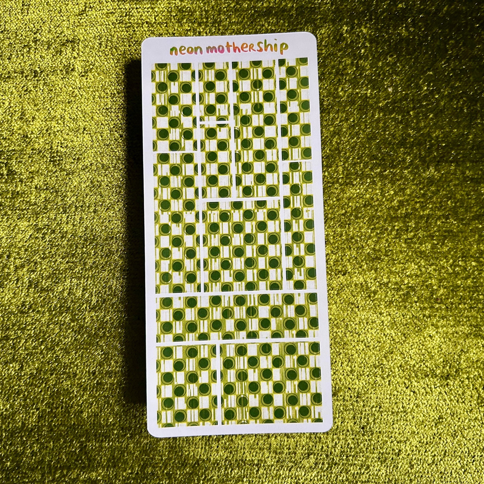 sticker sheet with green and white pattern on a textured green surface