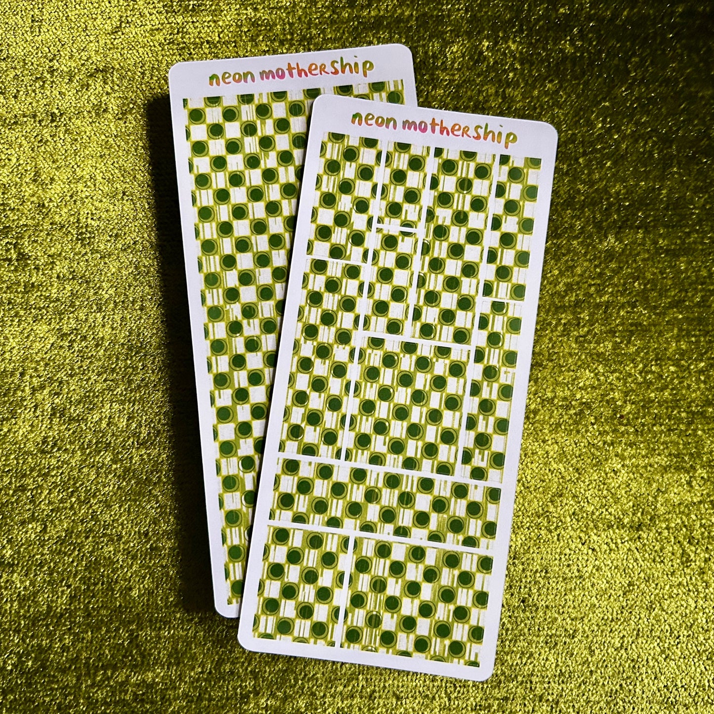 Two green and white checkered sticker sheets with 'neon mothership' text on a green textured background