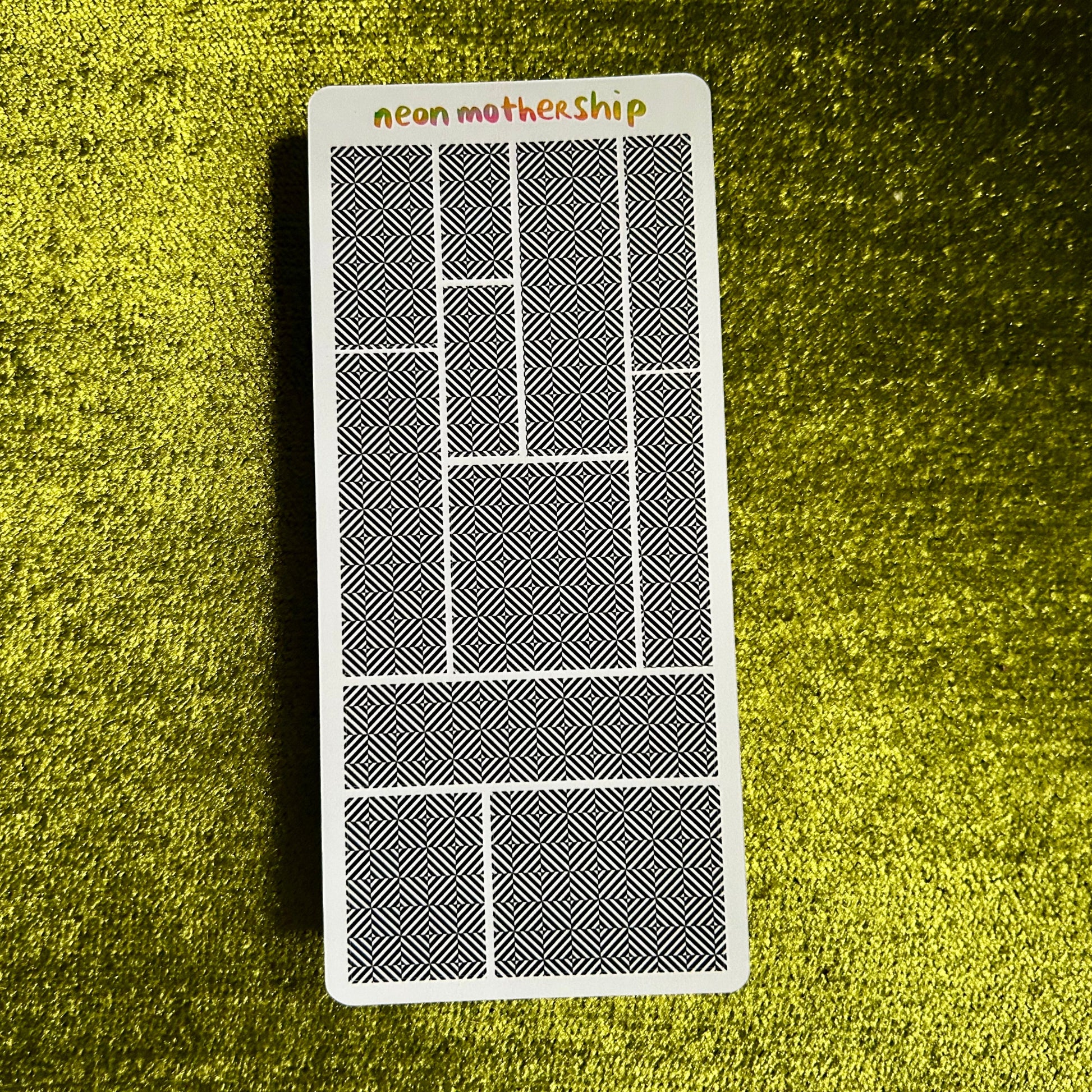 sticker sheet with geometric design on a textured green surface