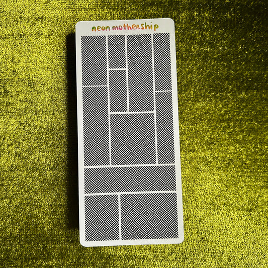 sticker sheet with geometric design on a textured green surface