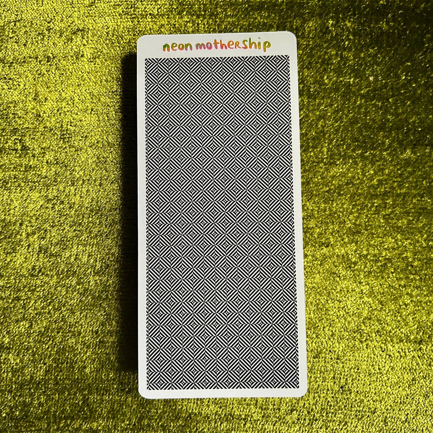 sticker sheet with geometric pattern on a textured green surface