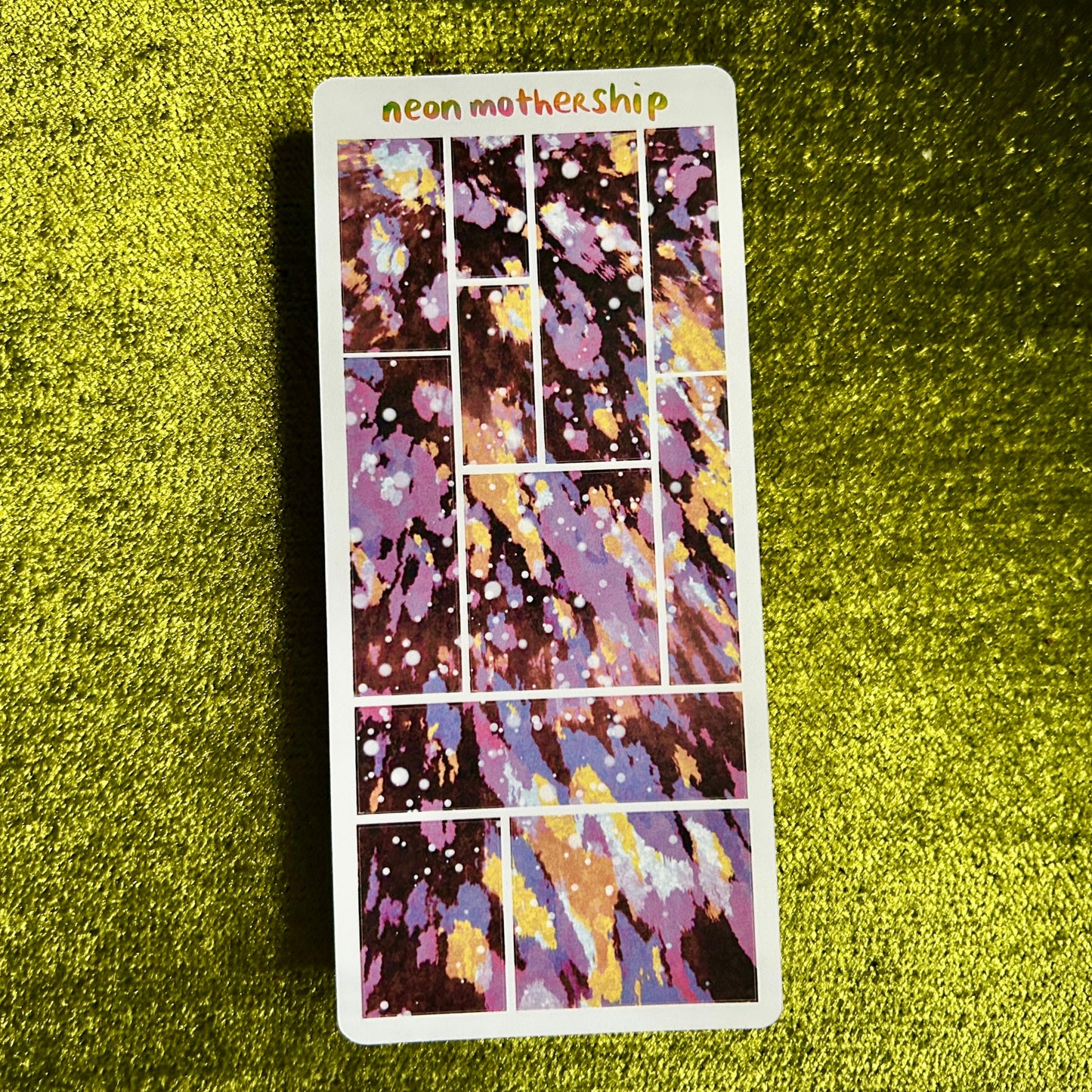 Colorful sticker sheet with 'neon mother ship' text on a green textured surface