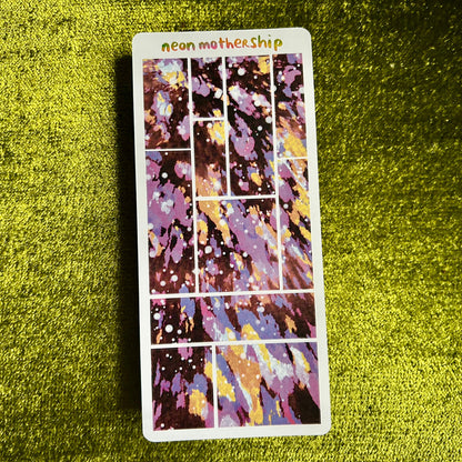 Colorful sticker sheet with 'neon mother ship' text on a green textured surface