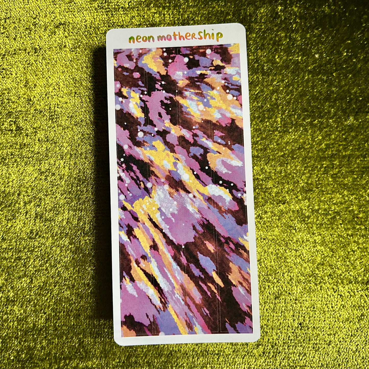 Colorful sticker sheet with 'neon mothership' text on a green textured surface